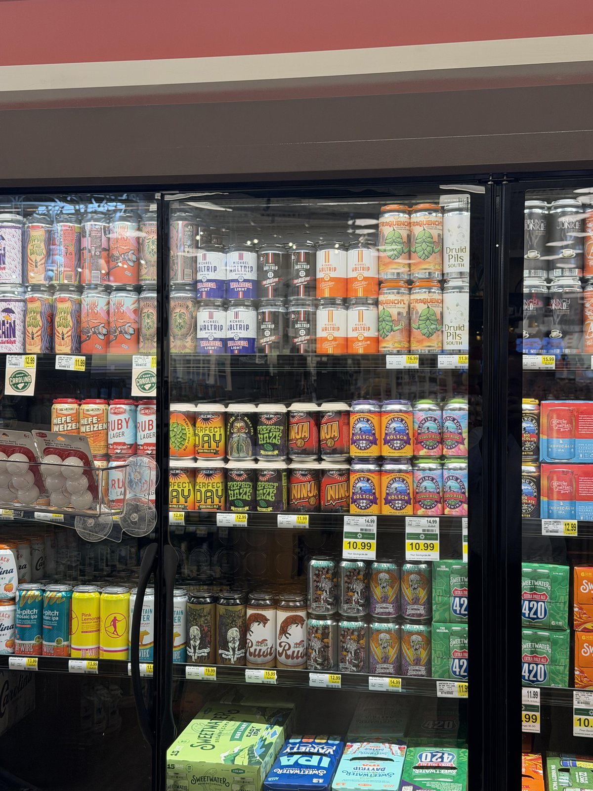 The beer cooler at the new Kannapolis Lowes Foods, rows of craft cans behind the glass.